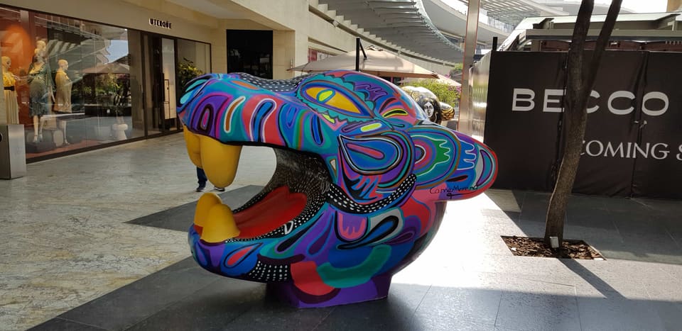 Pieza volumétrica policromada exhibida en pasillo de centro comercial